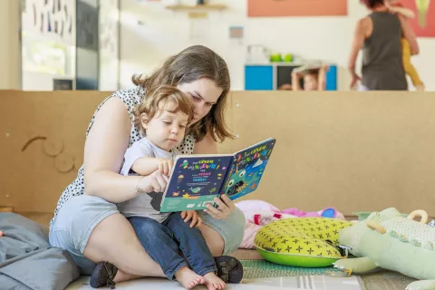 assistante maternelle qui fait la lecture à un jeune enfant