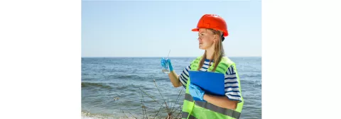 Jeune femme au bord de l'eau venant de faire un prélèvement