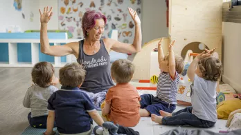 animateur d'activités entouré de jeunes enfants