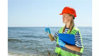 Jeune femme au bord de l'eau venant de faire un prélèvement